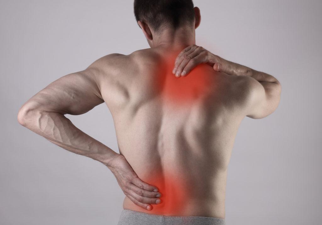 Muscular Man suffering from back and neck pain. Incorrect sitting posture problems Muscle spasm, rheumatism. Pain relief, ,chiropractic concept. Sport exercising injury